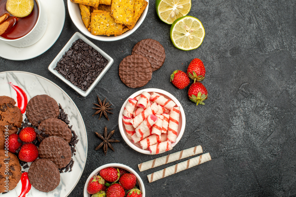 top view choco biscuits with candies and tea on dark floor sweet cookie photo top view choco biscuits with candies and tea on dark floor sweet cookie photo