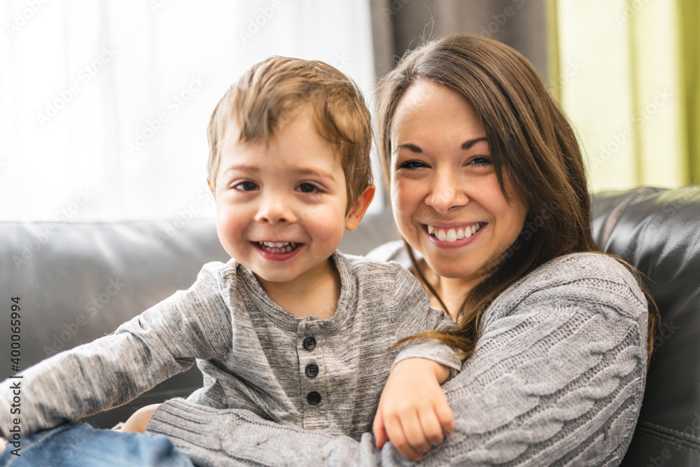Portrait of smiling little boy with mother on sofa Portrait of smiling little boy with mother on sofa