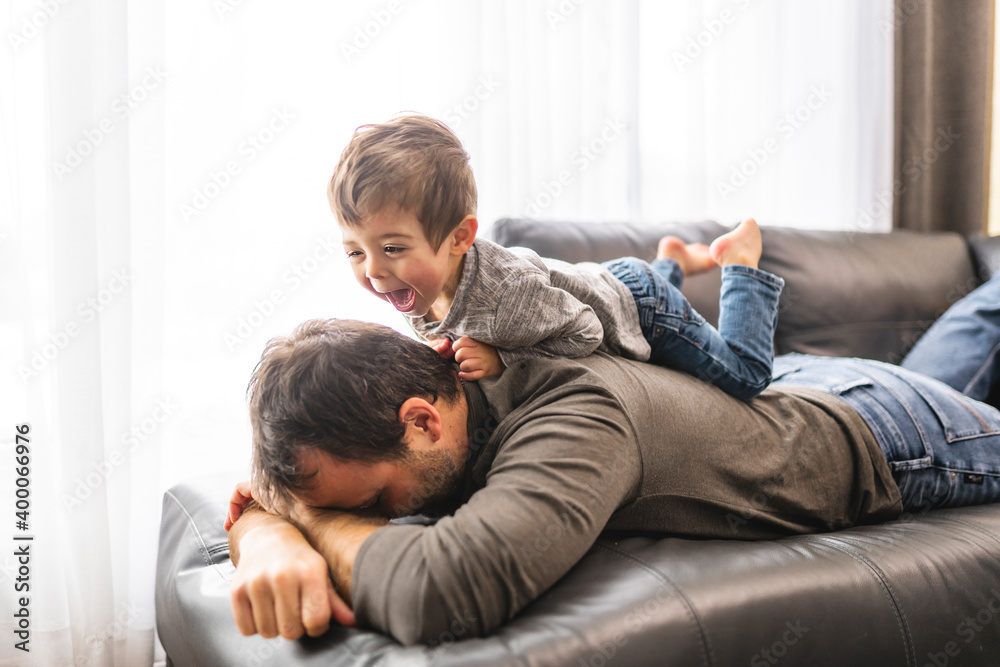 Tired young father with boy on back a concept of hyperactive children and tired parents