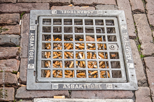 Haarlem, The Netherlands,Septemebr 9, 2019: ash tray filled with smoked cigarettes, integrated in the pavement of a downtwon street photo