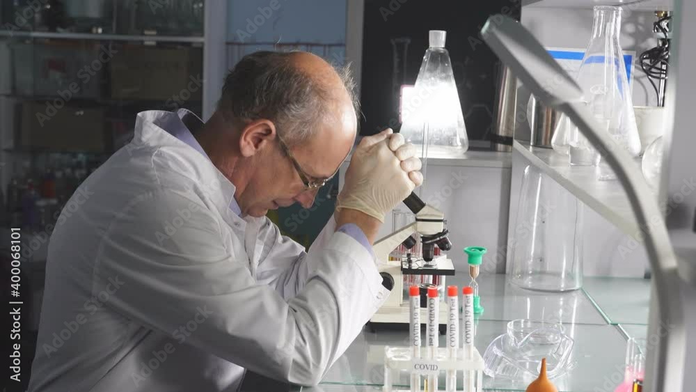 Tired man scientist,crashing, with failed experiments and working long hours, sit upset looking down, in laboratory. Tired man scientist,crashing, with failed experiments and working long hours, sit upset looking down, in laboratory.