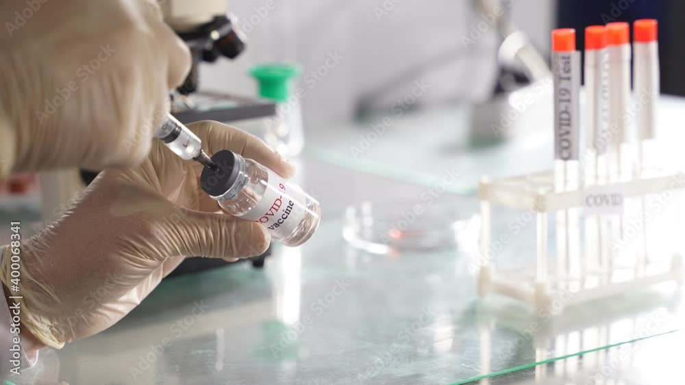 close-up video of covid-19 vaccine bottle in hands of researcher, pick up fluid from bottle tube for research close-up video of covid-19 vaccine bottle in hands of researcher, pick up fluid from bottle tube for research