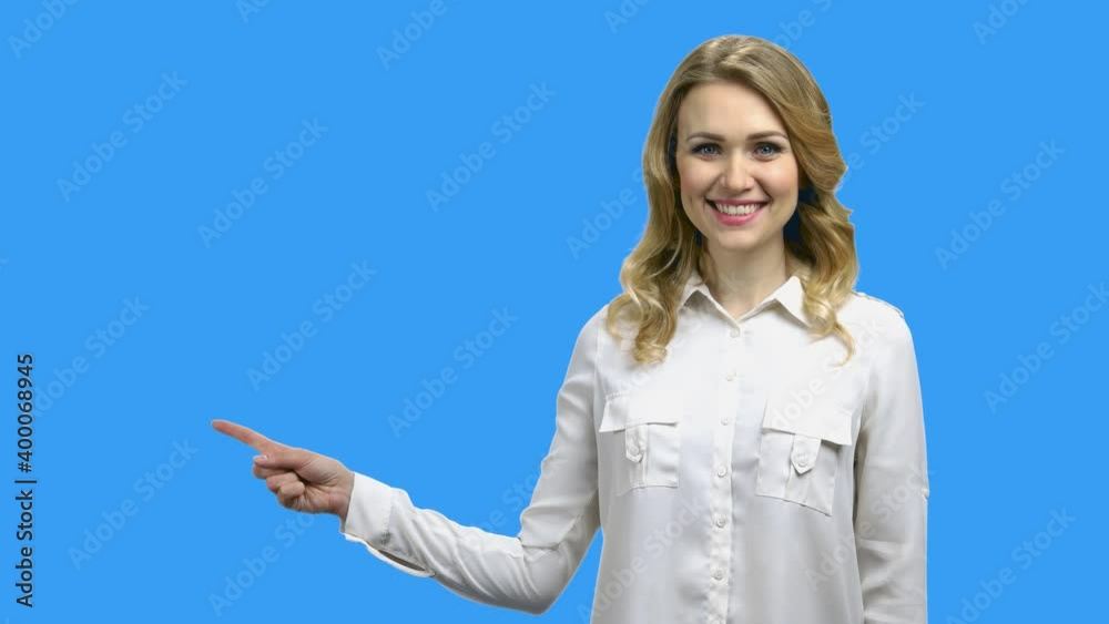 Young charming woman pointing with finger to copy space. Advertising and promotion concept. Selling time concept.