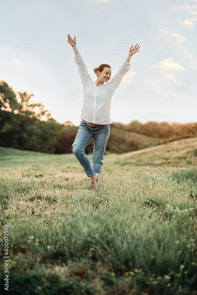 Outdoor Lifestyle portait of happy pregnant woman expecting baby at sunset in nature. Expecting belly. Concept of pregnancy, maternity. Outdoor Lifestyle portait of happy pregnant woman expecting baby at sunset in nature. Expecting belly. Concept of pregnancy, maternity.