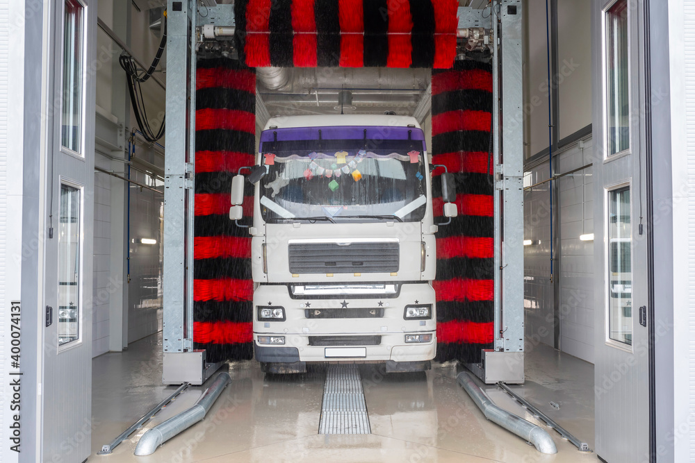 Truck at a car wash using high pressure water with detergents. Truck