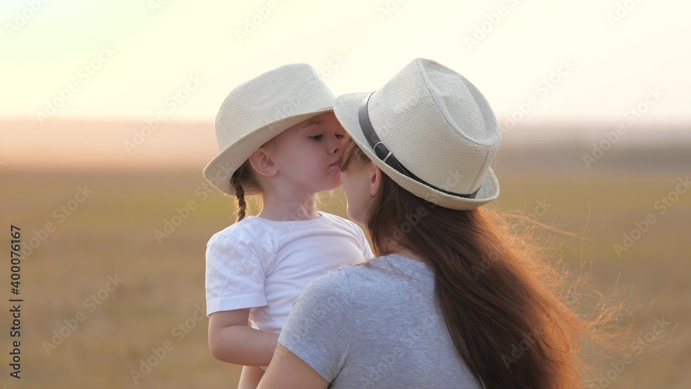Happy little daughter loves mom, child and mother hug in park. Mom and baby hug. Happy family, mom and daughter in field play on grass. concept of happy family and healthy children. Baby loves mommy