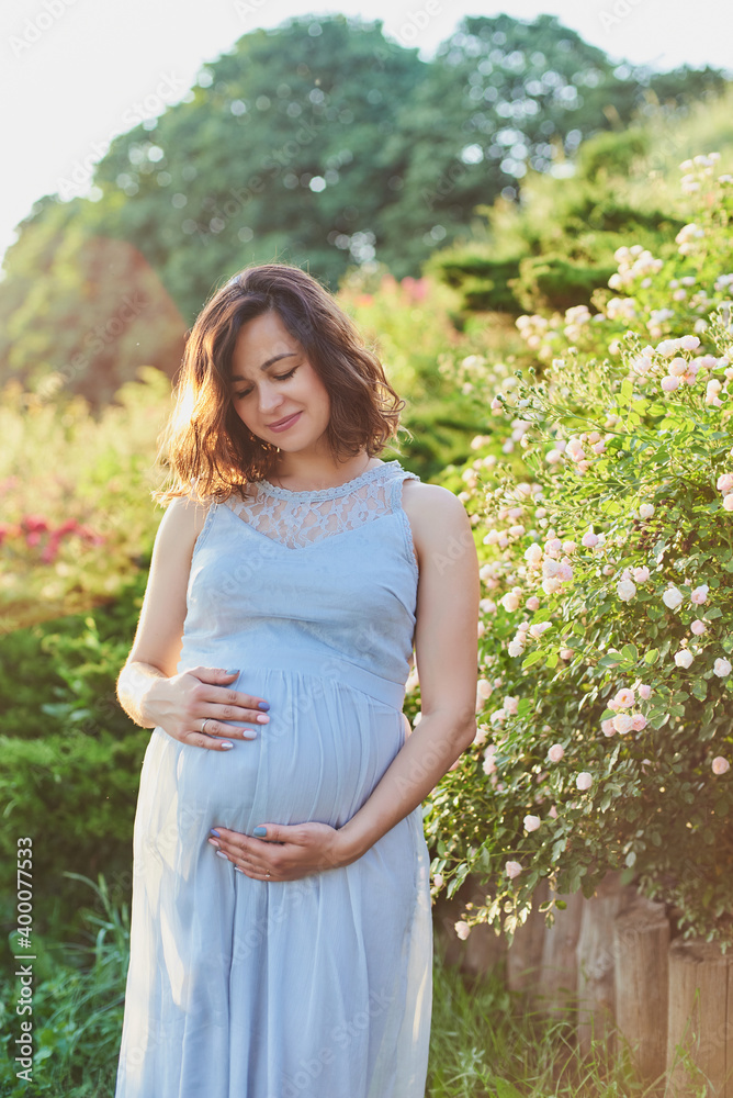 Beautiful pregnant woman relaxing in park future mom expecting child. Beautiful pregnant woman relaxing in park future mom expecting child.
