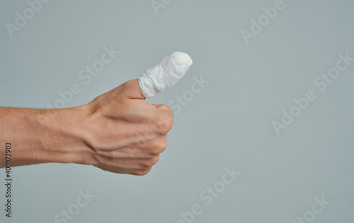 man in white t-shirt broken finger bandaged medicine