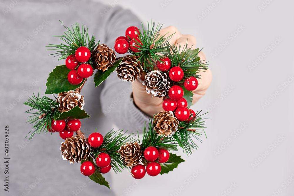 Hand with christmas wreath on grey background. Hand with christmas wreath on grey background.
