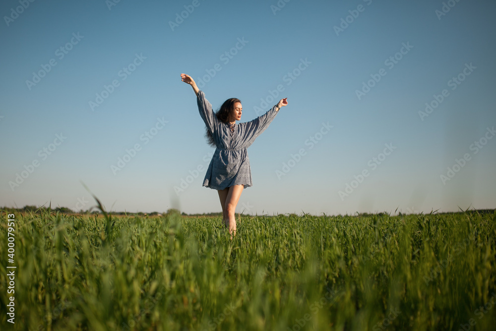 The girl walks in the field in summer. The girl walks in the field in summer.