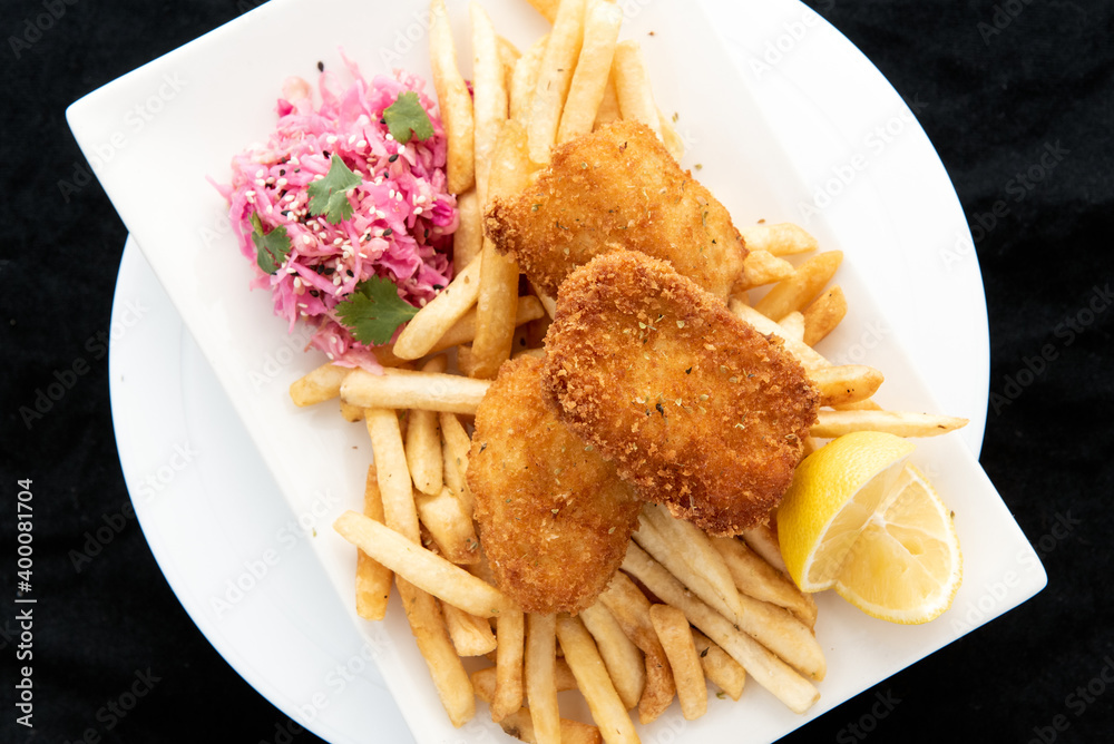 Overhead view of breaded halibut fish and chips served with french