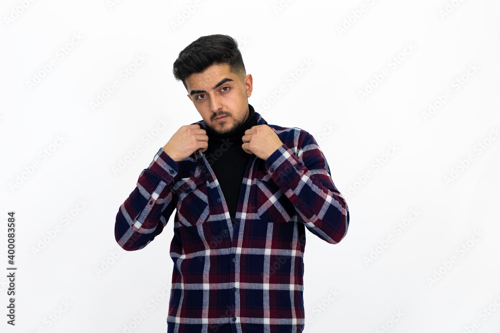 Young man posing in the studio. He wears a striped dark shirt. Young man posing in the studio. He wears a striped dark shirt.