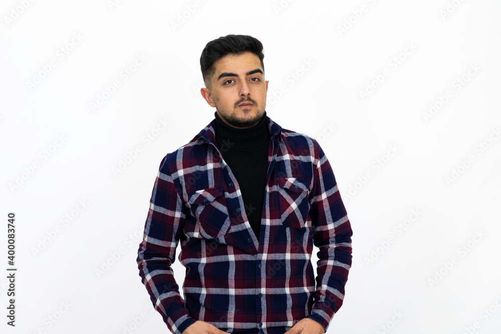 Young man posing in the studio. He wears a striped dark shirt. Young man posing in the studio. He wears a striped dark shirt.