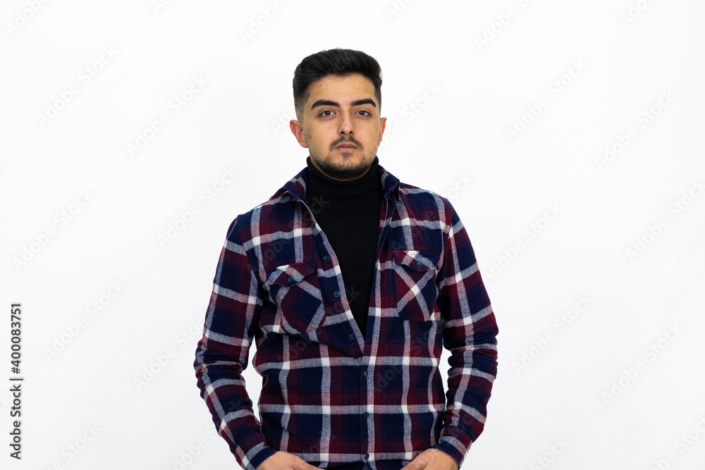 Young man posing in the studio. He wears a striped dark shirt. Young man posing in the studio. He wears a striped dark shirt.
