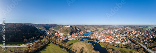 Bild einer Panorama Luftaufnahme mit einer Drohne der Stadtansicht des Markt Kallmünz Kallmuenz in Bayern und der Brücke über den Fluss Naab und Vils und der Burg Ruine auf dem Berg, Deutschland © stgrafix