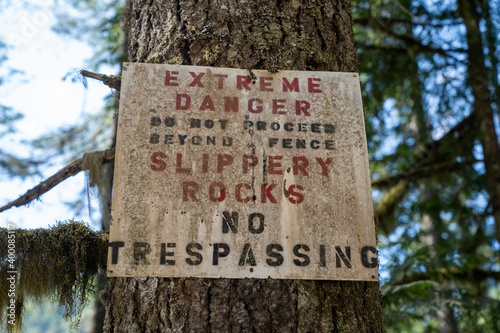 Sign warning of slippery rocks and danger, no trespassing