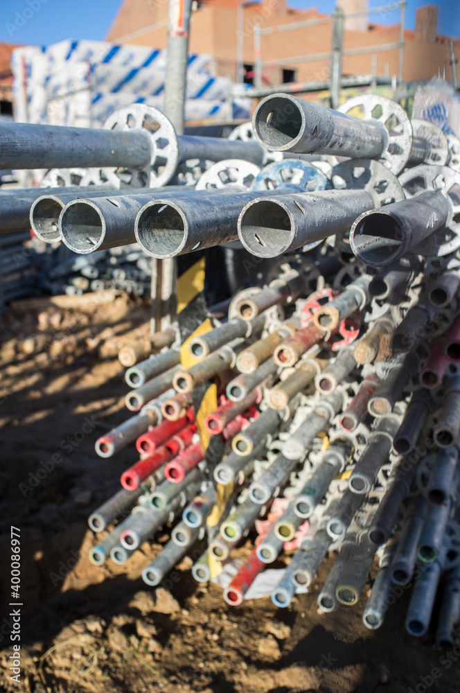 Fototapeta premium Unmounted scaffolding elements piled at construction site