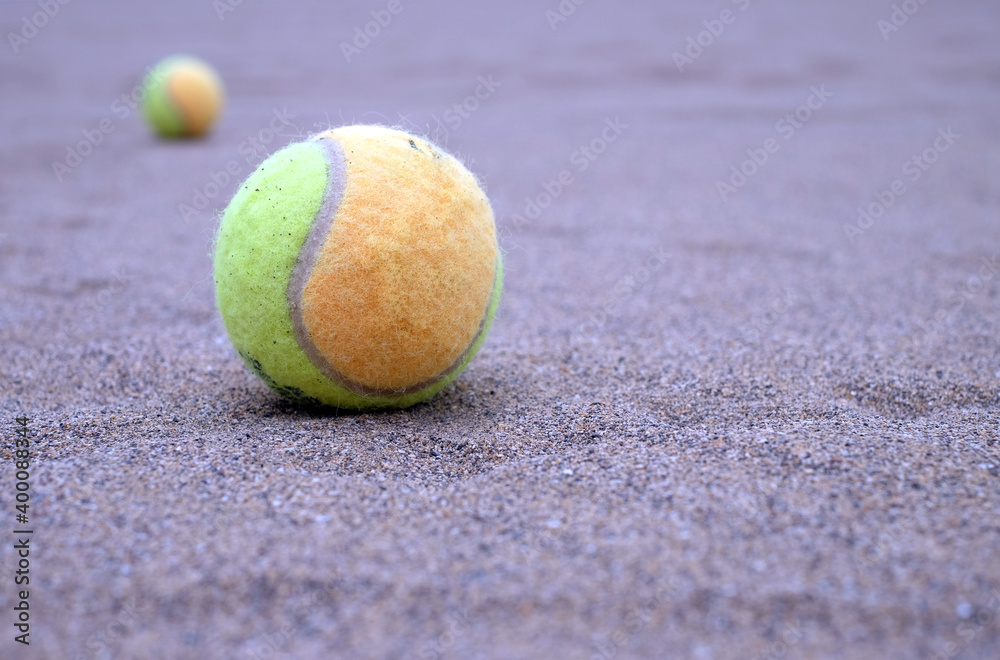 Paddle balls on the beach, selective perspective with second paddle ball in blurred background, cold light.