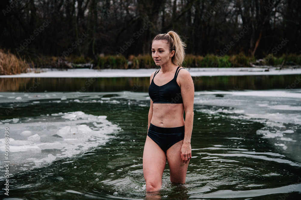 Young slender girl bathes in winter in a river hole Young slender girl bathes in winter in a river hole