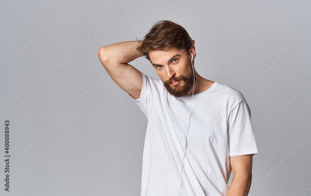 handsome man in headphones and in a white t-shirt on a gray background handsome man in headphones and in a white t-shirt on a gray background