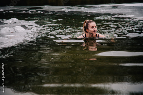 Fototapeta Naklejka Na Ścianę i Meble -  Young slender girl bathes in winter in a river hole