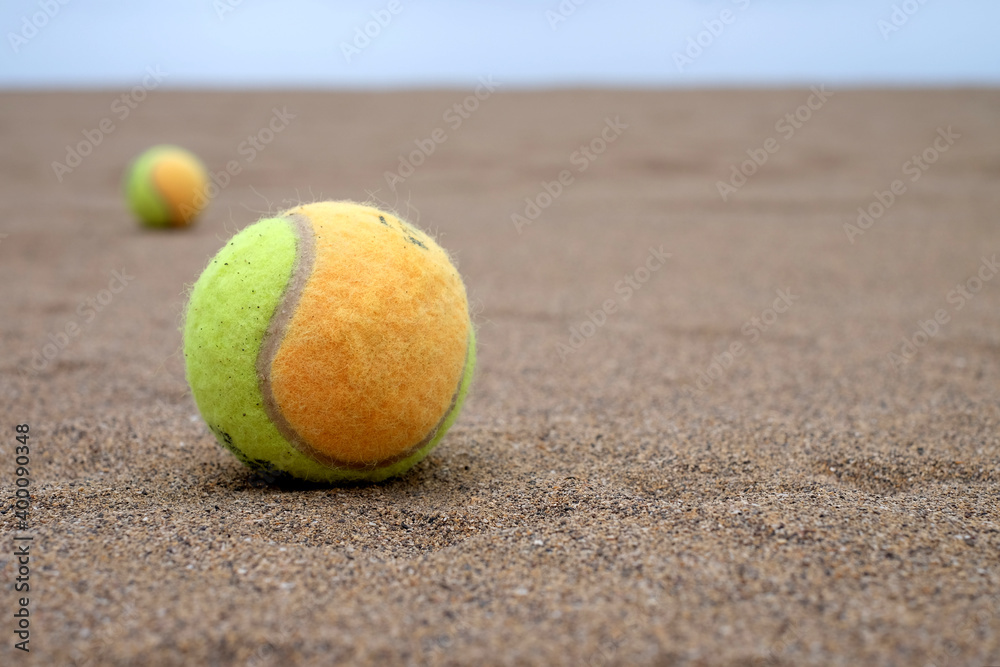 Paddle balls on the beach, selective perspective with second paddle ball and horizon in blurred background, warm light.