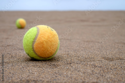 Paddle balls on the beach, selective perspective with second paddle ball and horizon in blurred background, warm light. © Daguimagery