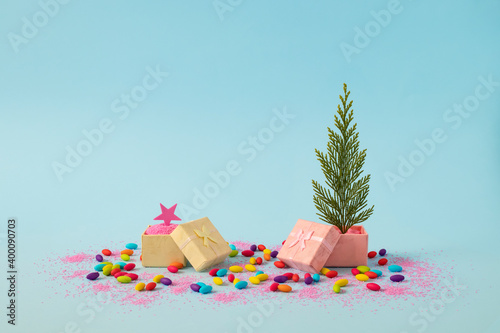 Christmas tree and a star in two gift box with decoration. Blue background. Winter holidays minimal concept.