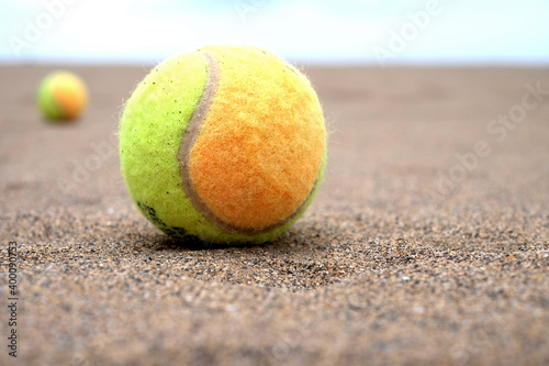 Paddle balls on the beach, selective perspective with second paddle ball and horizon in blurred background, warm light, light tone. © Daguimagery