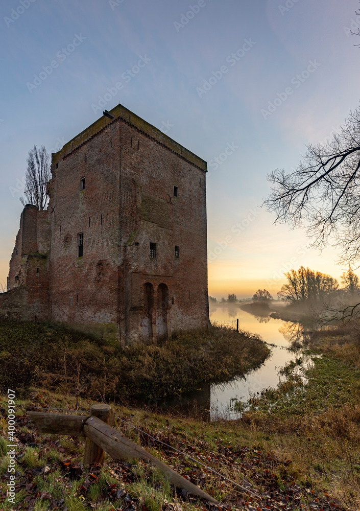 Vertical frame of remains of Nijenbeek castle in The Netherlands along the river IJssel at sunrise