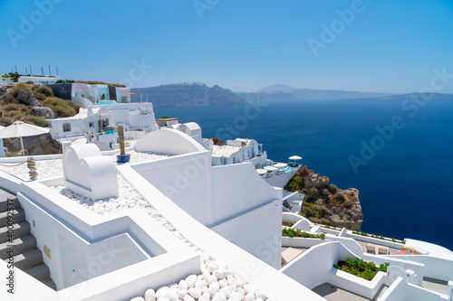 Balconies and roof tops in the village of Oia, Santorini. Architecture and landscape of Greece. Small cruze beside sthe shore. photo