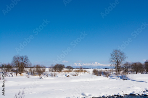 冬の河原と雪山と青空 大雪山 