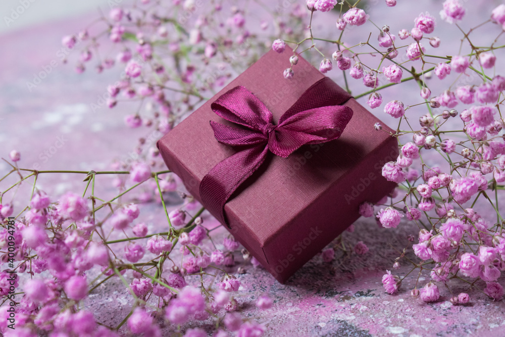 Gift box with burgundy color and gypsophile. Greeting card for Valentine's Day, anniversary, Mother's Day and birthday greetings, has a copy of the space Gift box with burgundy color and gypsophile. Greeting card for Valentine's Day, anniversary, Mother's Day and birthday greetings, has a copy of the space