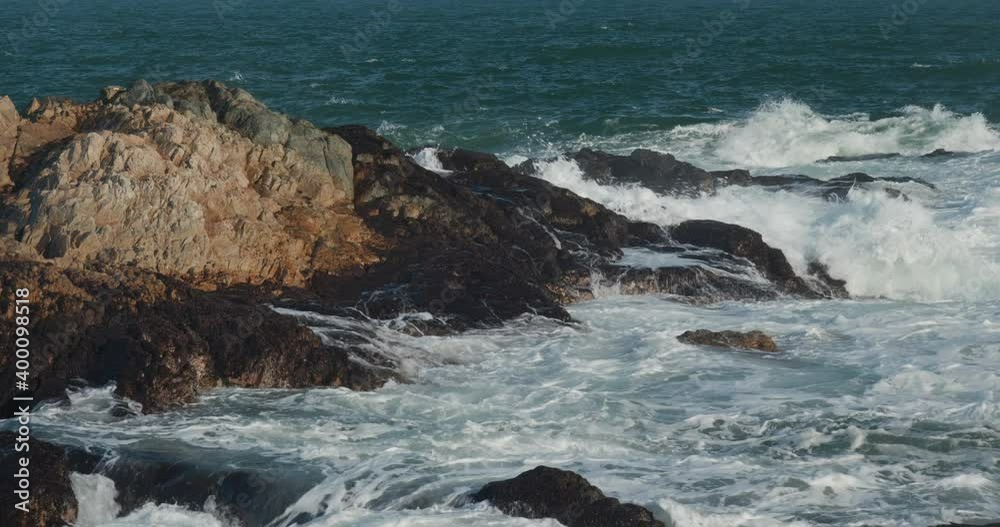 Ocean waves splash against rock on island Ocean waves splash against rock on island