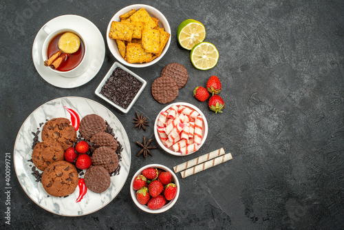 top view choco biscuits with candies and tea on the dark background sweet cookie photo