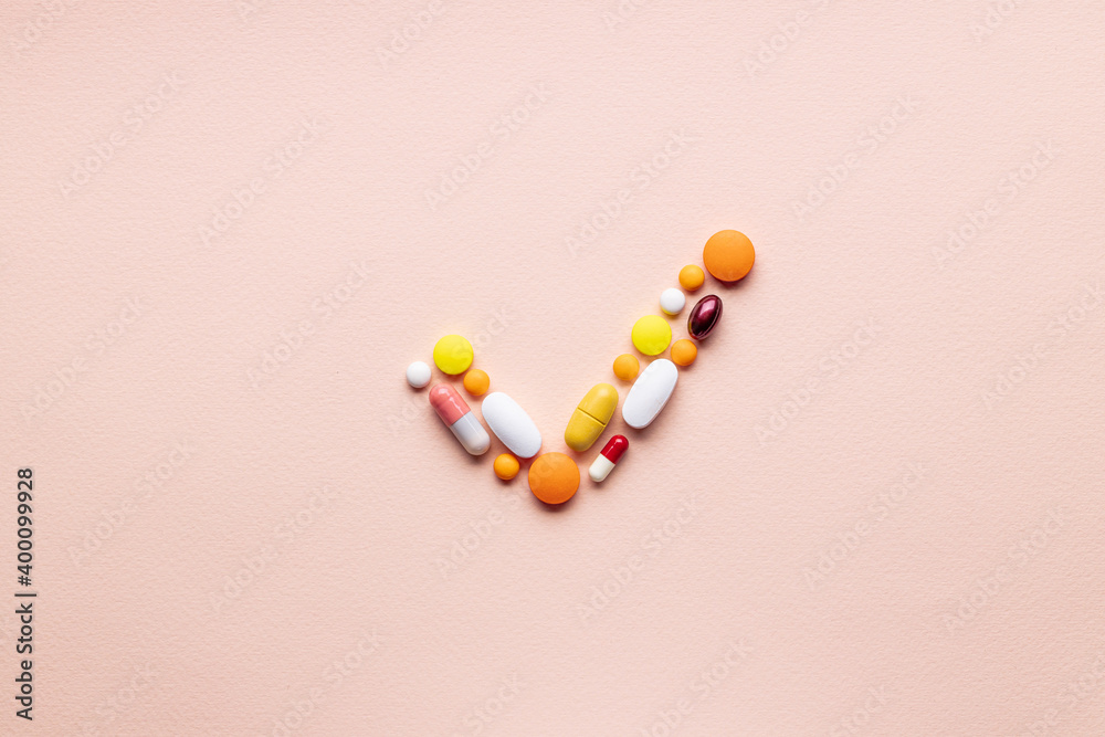 medical pills check mark symbol isolated on pink background. medicine approve sign concept. outer space. above view medical pills check mark symbol isolated on pink background. medicine approve sign concept. outer space. above view