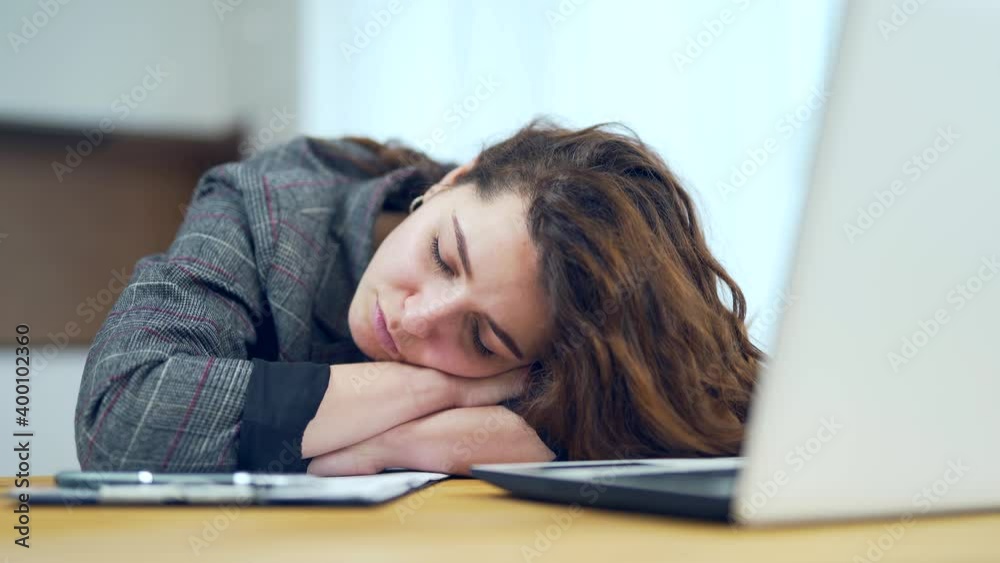 Young tired woman fell asleep after hard work with laptop and documents. Female feeling tired during studying from home. work and study from home. Overworked stressed day Young tired woman fell asleep after hard work with laptop and documents. Female feeling tired during studying from home. work and study from home. Overworked stressed day