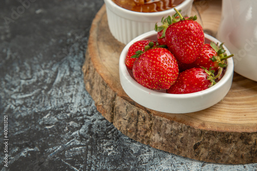 front view fresh strawberries with honey on a dark background fruit sweet jelly