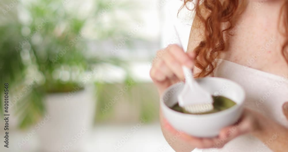 Beautiful young woman with henna hair dye at home Beautiful young woman with henna hair dye at home