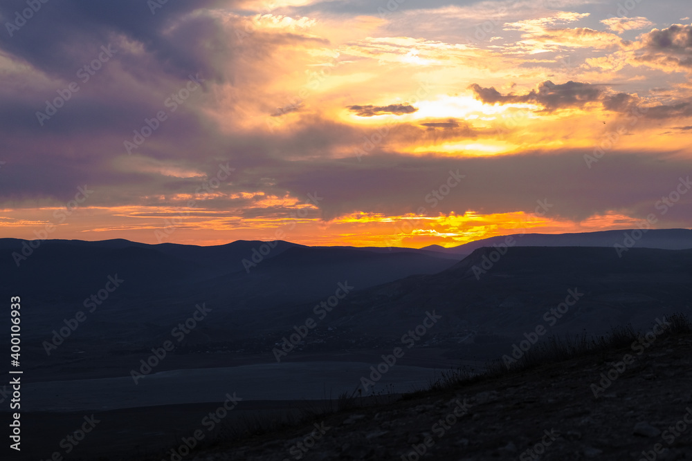 sunset with views of mountains in Crimea. Blue mountains and bright yellow sun. landscape and beautiful background