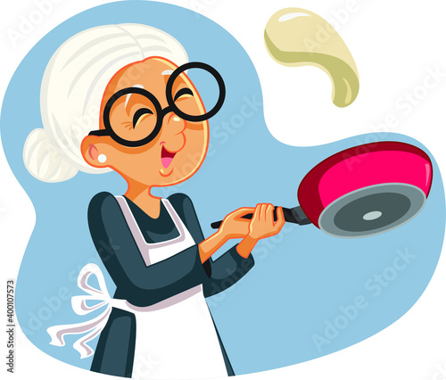 Cheerful Grandmother Flipping Pancakes for Breakfast