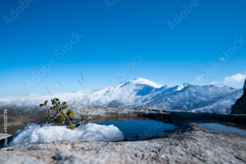 Snowy mountain and puddle on the rock