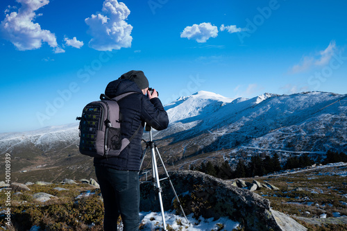 Young man taking photo of the snowy mountain