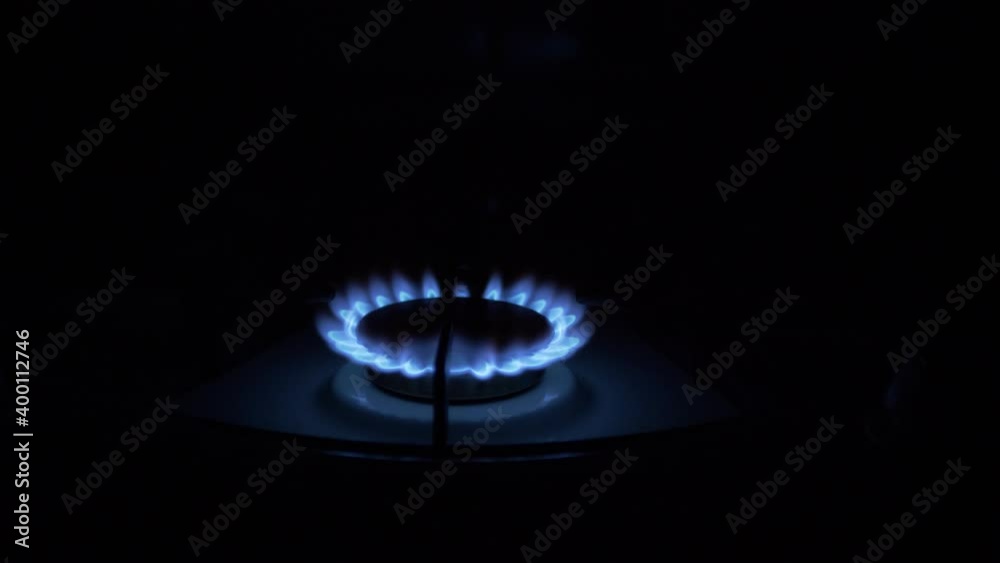Gas Burner On, Glowing with Blue Flame, at Night in Kitchen. Close-up Gas Burner On, Glowing with Blue Flame, at Night in Kitchen. Close-up