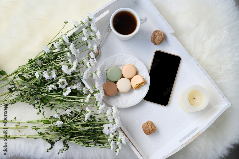 white wooden tray with black tea, coffee, plate with macaroon cakes, flowers, candles, blank screen phone, concept of technology, time, joys of life, flatley, top view white wooden tray with black tea, coffee, plate with macaroon cakes, flowers, candles, blank screen phone, concept of technology, time, joys of life, flatley, top view