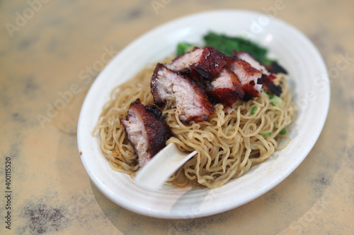 Wonton noodles with roasted pork belly and Char Siu, a Cantonese Chinese cuisine served dry with soy sauce and roasted pork.   