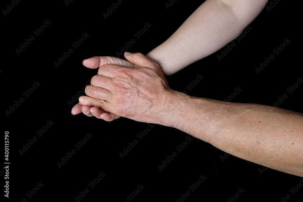 male and female hands together on black background, old skin with wrinkles and veins, concept of health, age-related changes, love, tender relationship of a couple in love, isolated image male and female hands together on black background, old skin with wrinkles and veins, concept of health, age-related changes, love, tender relationship of a couple in love, isolated image