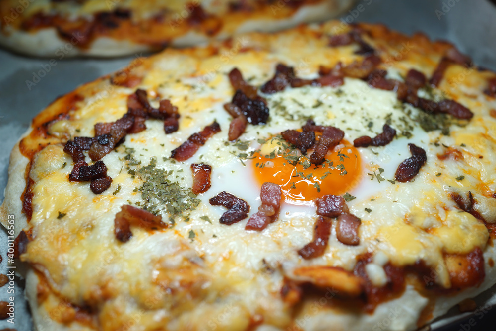 Pizza with bacon, melted cheese, olives, mushrooms and cherry tomatoes. Soft focus image. Pizza with bacon, melted cheese, olives, mushrooms and cherry tomatoes. Soft focus image.