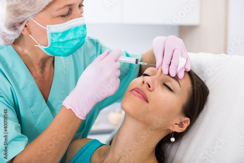 Young woman getting injection for facial correction procedure in esthetic clinic