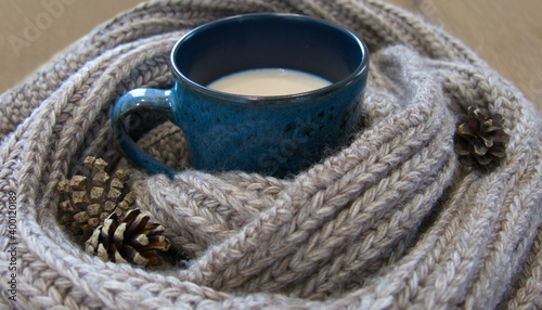 Photos Warmth and comfort in a hot cup and a knitted scarf